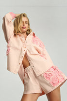 ELSHAM BOUTIQUE model wearing pink petal high-waisted denim shorts and matching embroidered denim shirt