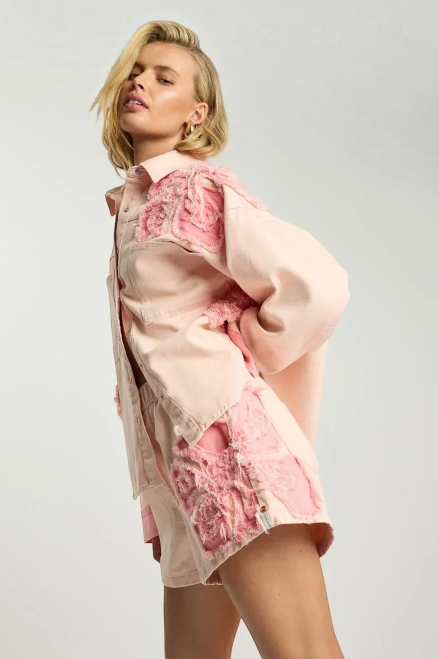 Model wearing ELSHAM BOUTIQUE pink petal oversized cotton denim shacket with raw frayed edge detailing