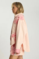 ELSHAM BOUTIQUE pink petal oversized denim shacket with frayed detailing worn by a blonde model, side view