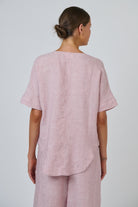 Back view of ELSHAM BOUTIQUE radish pink linen top with short sleeves and a relaxed oversized fit