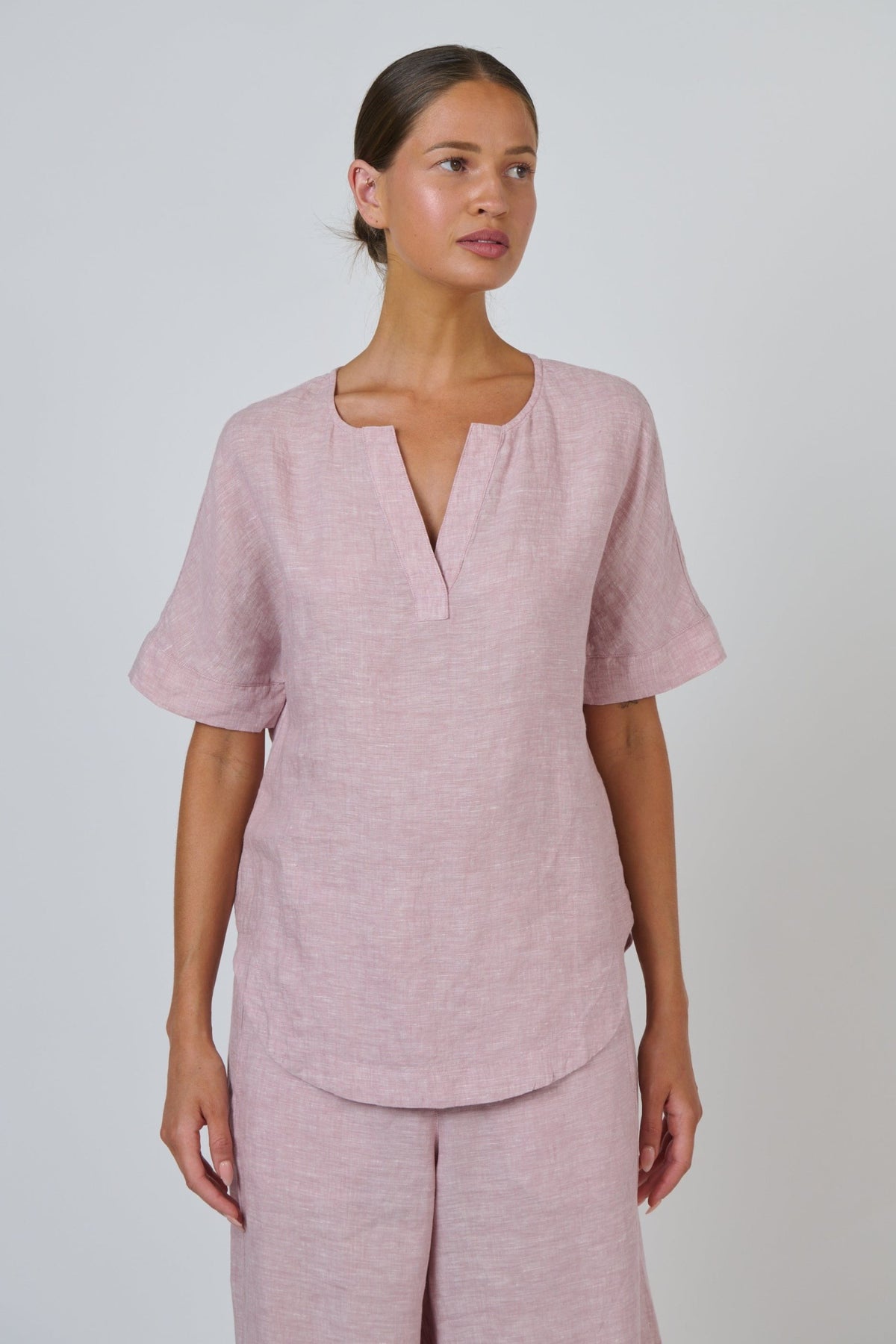 ELSHAM BOUTIQUE GA718 radish pink linen top with a split V-neckline and relaxed short sleeves on a model
