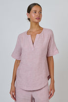ELSHAM BOUTIQUE radish pink linen top with a split V-neckline and relaxed short sleeves on a model