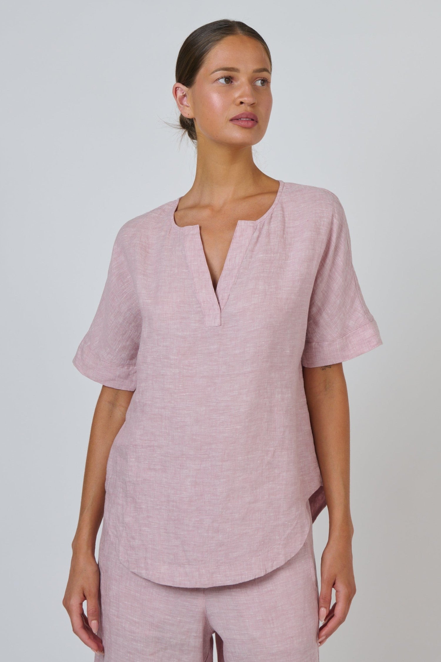 ELSHAM BOUTIQUE radish pink linen top with a split V-neckline and relaxed short sleeves on a model