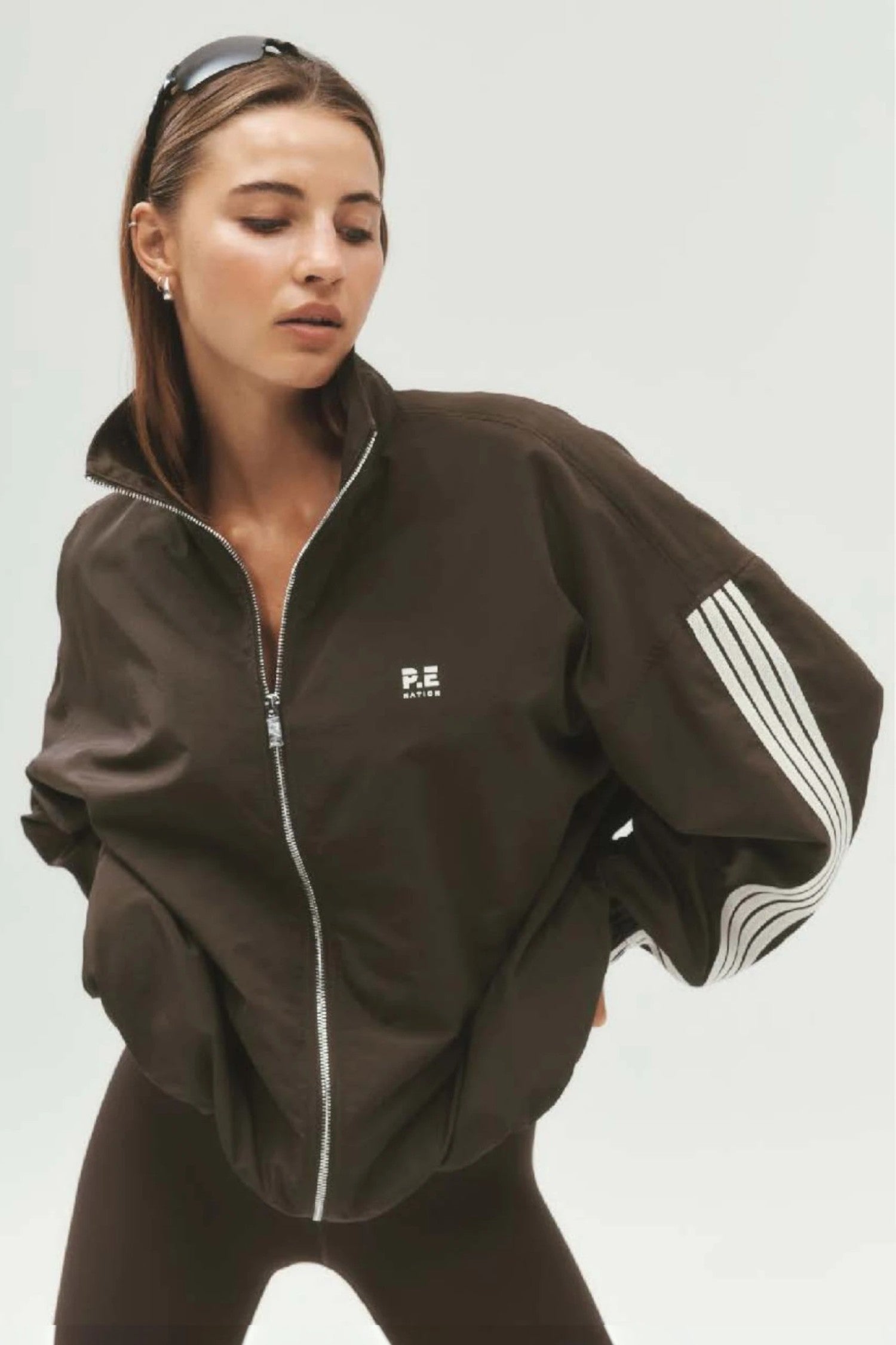 ELSHAM BOUTIQUE oversized coffee brown Radius jacket with funnel neck, side stripe detail, and chest branding.