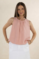 Model wearing an ELSHAM BOUTIQUE Samara Top in musk pink, featuring a sleeveless linen-tencel blend and gathered hem.
