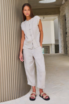 Model wearing ELSHAM BOUTIQUE sand linen cropped tapered pants with an elasticated waistband and side pockets.