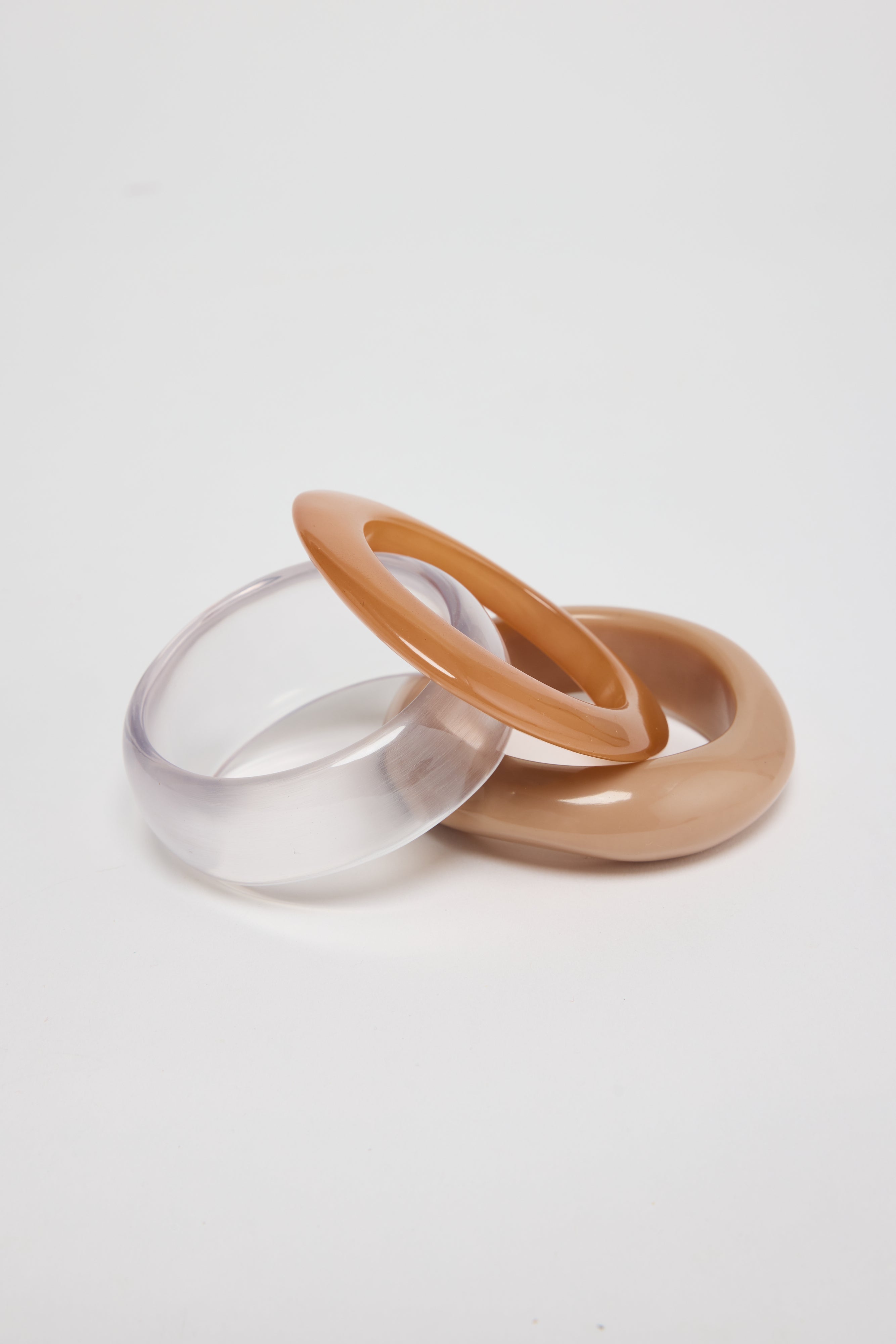 ELSHAM BOUTIQUE Serenity Bangle Set featuring three neutral-toned resin bracelets in clear, tan, and beige.