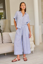 Model wearing ELSHAM BOUTIQUE silver linen wide-leg cropped pants with an elastic waistband and oversized pockets.