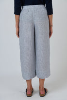 Back view of ELSHAM BOUTIQUE silver linen wide-leg cropped pants with an elasticated waistband on a model.