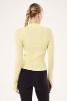 Back view of ELSHAM BOUTIQUE soft yellow rib knit zip jacket with high neck and long sleeves on a model