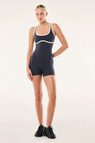 ELSHAM BOUTIQUE Solis playsuit in marine blue and black with a square neck, adjustable straps, and bike short length.