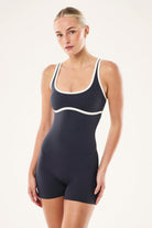 ELSHAM BOUTIQUE Solis playsuit in marine blue and black with a square neck and bike short silhouette on a model.