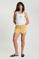 ELSHAM BOUTIQUE Bandits low waist denim shorts in sunfade yellow with distressed details and rolled hem on a model
