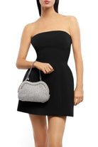 ELSHAM BOUTIQUE Taylor silver metallic crochet clutch bag with a chain handle held by a model in a black dress.