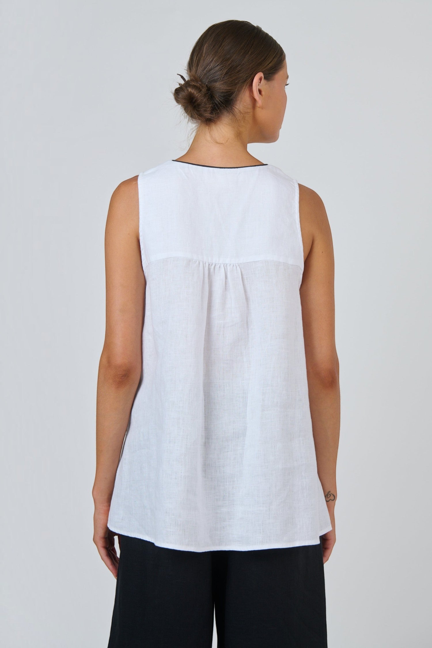Back view of ELSHAM BOUTIQUE white linen sleeveless top with gathered back yoke detail and A-line silhouette