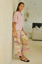 ELSHAM BOUTIQUE model wearing GA398 wide-leg linen trousers with a multi-coloured abstract print and side pockets.