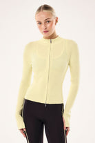 ELSHAM BOUTIQUE soft yellow rib knit zip-up jacket with high neck and long sleeves worn by a model.